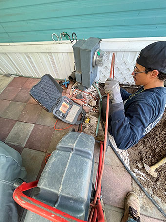 Technician running a sewer camera and locator from a patio