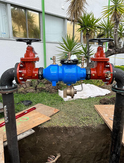 Backflow preventer assembly with red gate valves on a commercial lawn