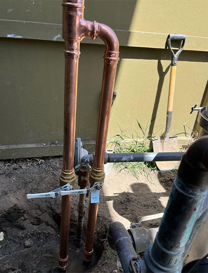 New copper water-service risers with shut-off valves at an exterior wall