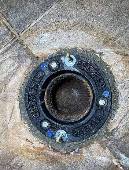 Cast-iron closet flange set into a tiled floor